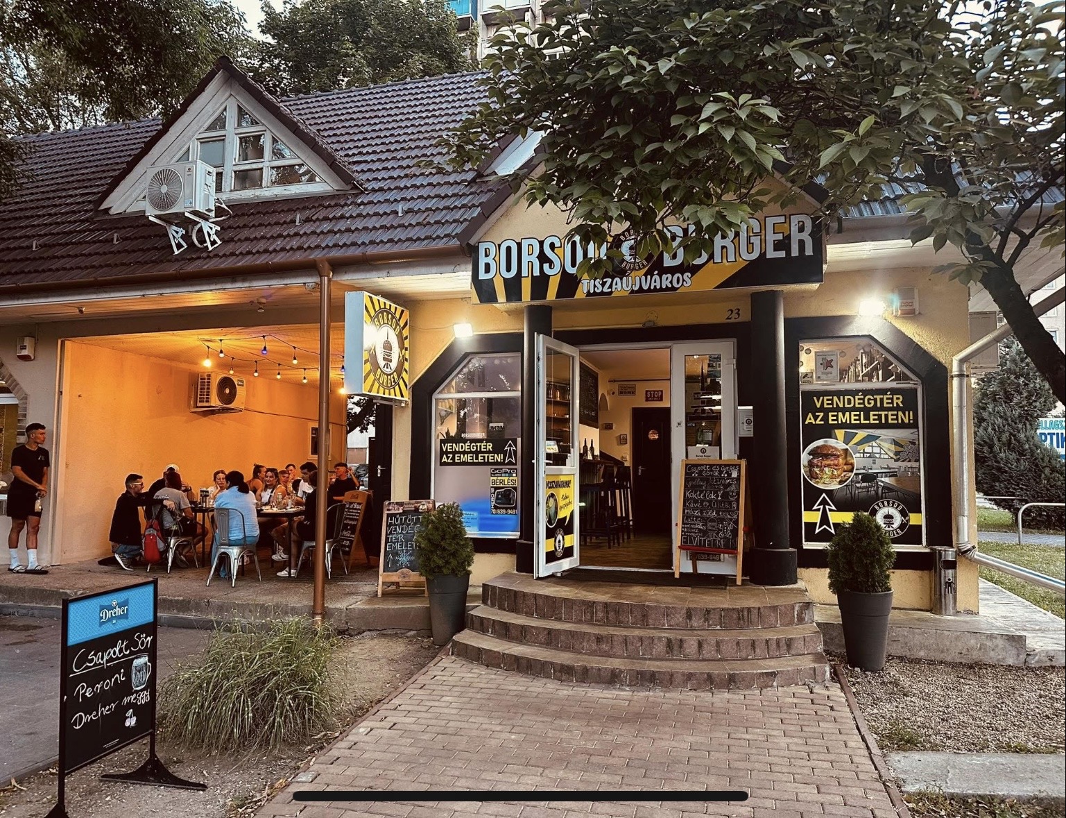 A tiszaújvárosi Borsod Burger bejárata és terasza esti fényekben